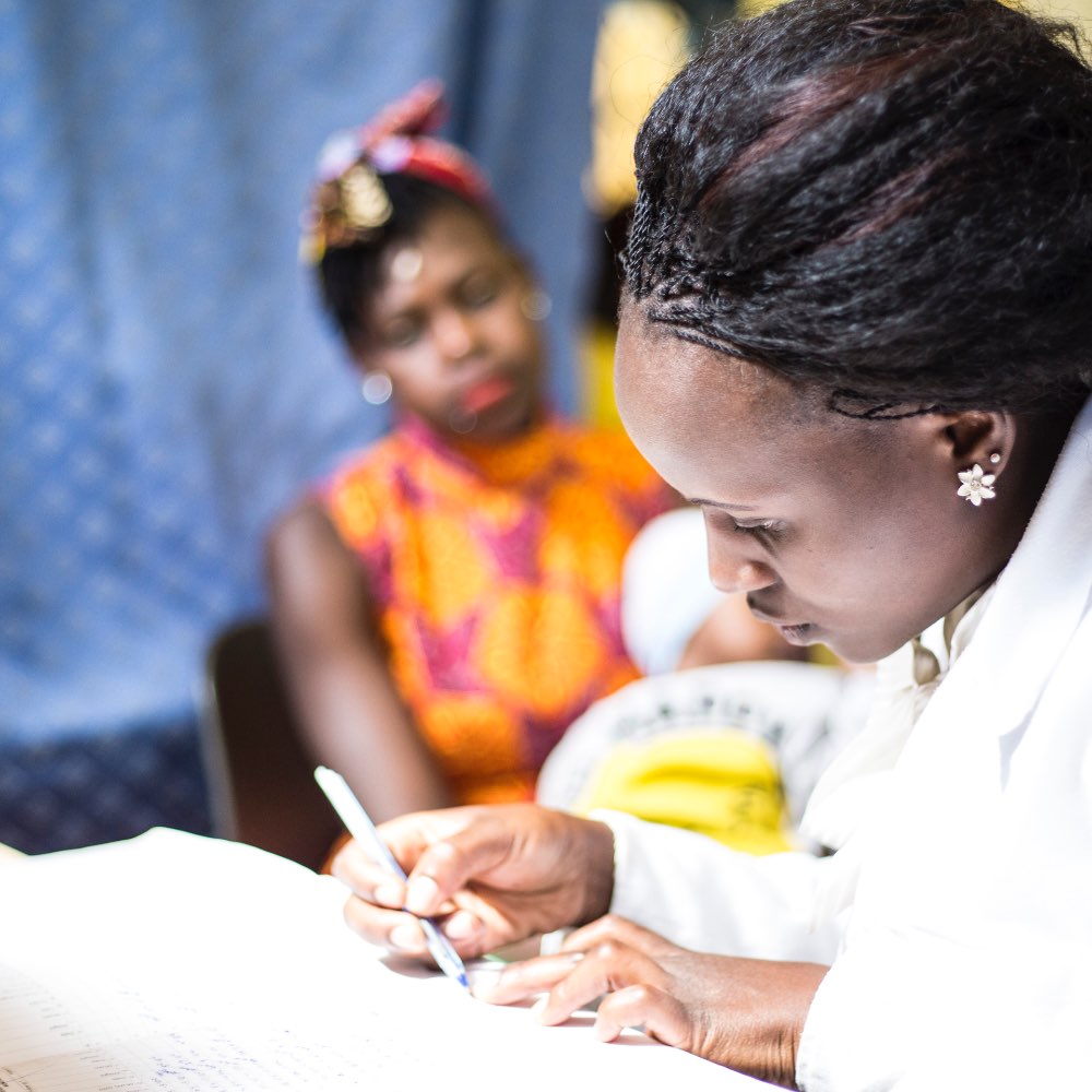 A woman writing on a form at the CDC in Kenya